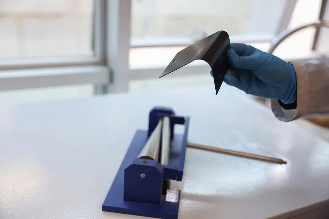 Kaplanmış metal numune üzerinde gerçekleştirilen bükme testinde kaplamanın esneme ve deformasyon dayanımının değerlendirildiği laboratuvar uygulaması.