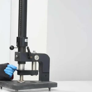 Kaplanmış metal numune üzerinde gerçekleştirilen darbe testinde kaplamanın ani mekanik etkilere karşı dayanıklılığının değerlendirildiği laboratuvar uygulaması.