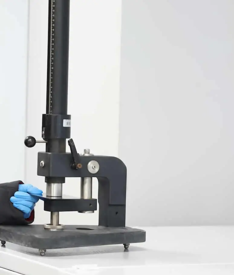 Kaplanmış metal numune üzerinde gerçekleştirilen darbe testinde kaplamanın ani mekanik etkilere karşı dayanıklılığının değerlendirildiği laboratuvar uygulaması.